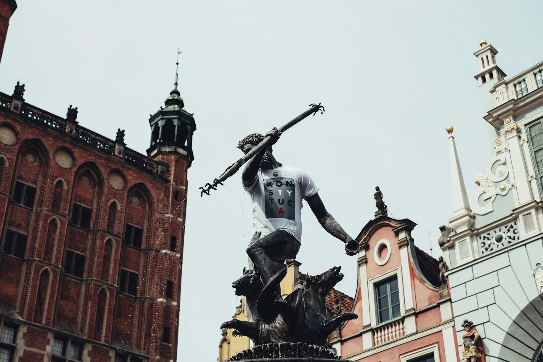 Ilustracja przedstawiająca nowoczesną architekturę "Zielonych Tarasów" w Oświęcimiu na tle historycznej zabudowy miasta po zmroku.